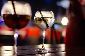 Beautiful row line of different colored alcohol cocktails on a party, martini, vodka,and others on decorated catering bouquet table on open air event, picture with beautiful bokeh