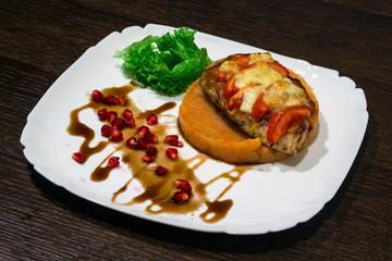 meat dish. Steak with mashed potatoes, greens, soy sauce and pomegranate seeds	