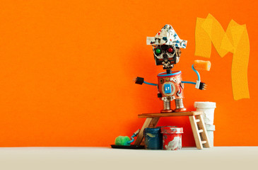 Funny decorator robot repaints the wall of the room orange color. Creative painter robot toy,...