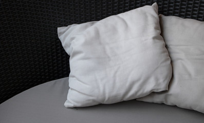 Close-up Blank white pillow on black couch background with copy space