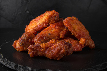 Spicy Wings on black background. Snack to beer. Fast food.