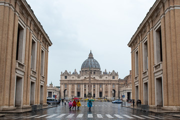 Persone con ombrelli e impermeabili colorati con lo sfondo della Basilica di San Pietro, Citta del Vaticano Roma
