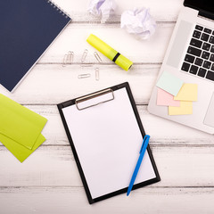 Planner on the wooden working table with computer. Blank white paper on working desk