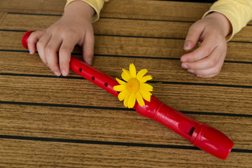 child playing and tuning red flute in a music school for education concept © Fertas