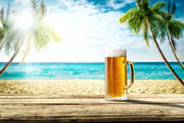 Summer background of wooden desk and cold beer. Free space for your decoration. Beach landscape...