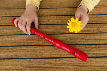 child playing and tuning red flute in a music school for education concept © Fertas