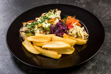 Grilled chicken breast with fries and salad, restaurant serving plate