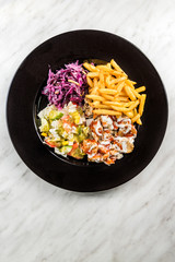 Turkish donner kebab with fries and salad on plate