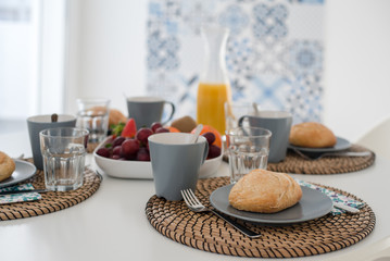 Plate with fresh crusty bread and glass of juice on grey plate
