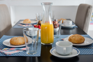 Plate with fresh crusty bread and glass of juice on white plate