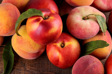 composition of many varieties of peach on a brown wooden background. fruits.