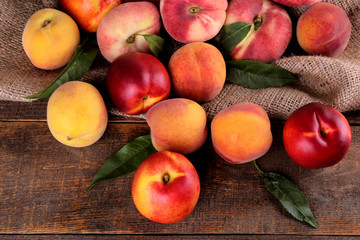 Fototapeta na wymiar composition of many varieties of peach on a brown wooden background. fruits.