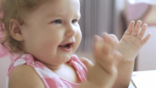 little beautiful girl claps her hands and rejoices at the achievement. concept of happiness, joy.