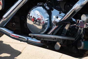 Red motorcycle reflected in chrome details of other motorcycle, concept