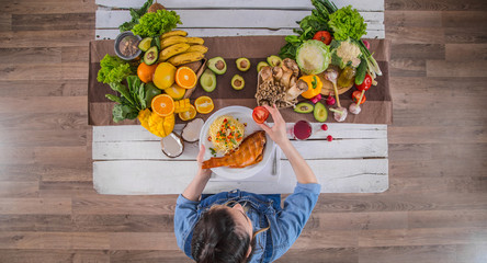 The woman at the dinner table with organic food , the view from the top.