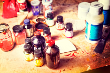 colors and utensils of an artist on a wooden table