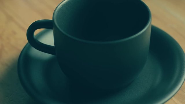 frischer Kaffee wird in eine schwarze Tasse gegossen