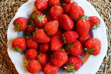 A plate of ripe and juicy strawberries.