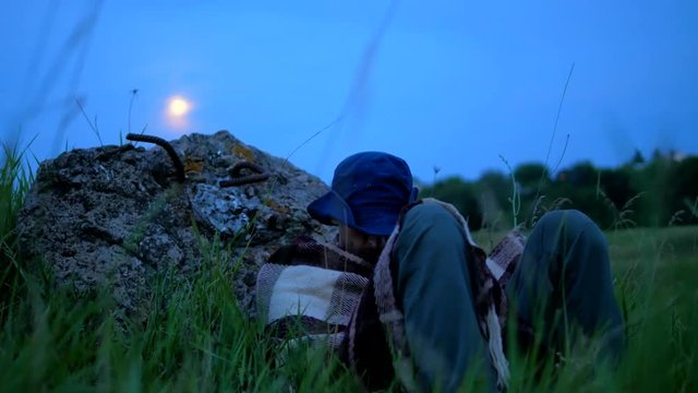 Sleeping traveler at valley with full moon at the sky