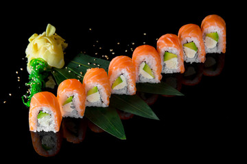 Sushi roll (Philadelphia) with salmon, smoked eel, avocado, cream cheese on black background. Sushi menu. Japanese food.