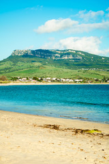 a tranquil beach scene looking at one of the hills surrounding bolonia in Andalucía, Spain 