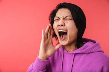 Photo closeup of angry asian guy 20s wearing sweatshirt screaming while being furious