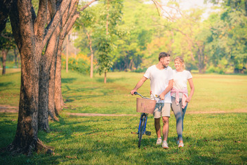 Portrait image of Young couple enjoying in the park at sunset. Concept romantic and love. Warm tone.