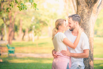 Portrait image of Young couple enjoying in the park at sunset. Concept romantic and love. Warm tone.