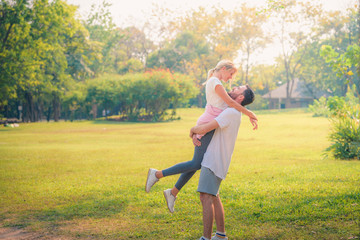 Portrait image of Young couple enjoying in the park at sunset. Concept romantic and love. Warm tone.