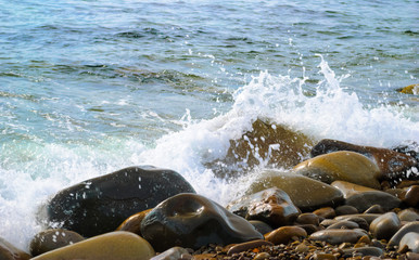 The sea waves rolling on the stony coast, a close up