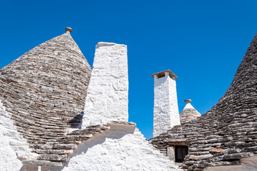 Fototapeta na wymiar Alberobello, Italy. The picturesque village of trulli. Stone houses built in the typical circular shape with cone roofs.