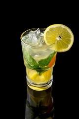 Alcoholic or non-alcoholic cocktail with lemon, lime and cucumber with the addition of liquor, vodka, champagne or martini. Cool drink isolated on black background. Cocktail card for a bar