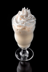 Milkshake. A cool drink of milk, ice cream, chocolate, vanilla, strawberries, on a black background with stones and ice. Cocktail card for a bar or restaurant iisolated on black 