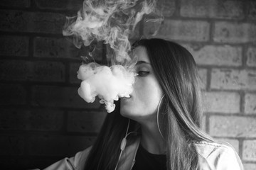 Vaping teenager. Young pretty white girl smoking an electronic cigarette  in vape bar. Bad habit. Black and white.