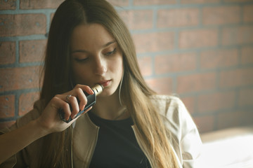 Vaping teenager. Young pretty white girl smoking an electronic cigarette in vape bar. Bad habit.