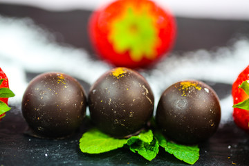 chocolate with gold leaf and powdered sugar, strawberry