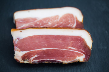 South Tyrolean bacon on slate, isolated