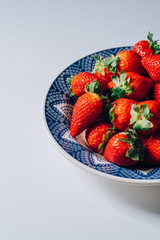 Fresh ripe strawberries in a blue and white plate