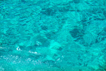 Texture of clear turquoise sea water surface. Can be used as summer background