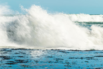 Sea waves hitting on the stones near the coast. White foam comes out of the waves white foam of a sea wave