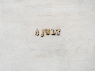 4 JULY. Wooden, unpainted letters on a white table. Closeup, top view. Beautiful photo with a space for your inscriptions. Congratulations to loved ones, relatives, family, friends and colleagues