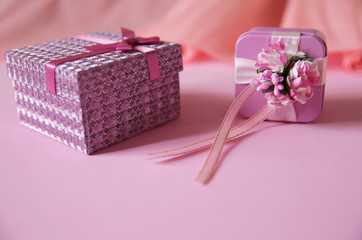 pink gift  box with red ribbon and bow and flower isolated on pink background.