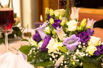Tischgesteck mit lila Blumen