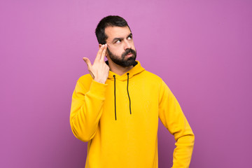 Handsome man with yellow sweatshirt with problems making suicide gesture