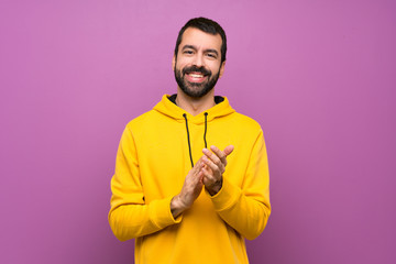 Handsome man with yellow sweatshirt applauding after presentation in a conference