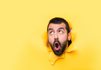 Man through a hole paper making surprise gesture