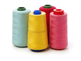 spools of thread for the textile industry on white background