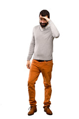 Fototapeta premium Handsome man looking far away with hand to look something over isolated white background