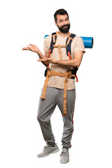 Hiker man extending hands to the side for inviting to come over isolated white background