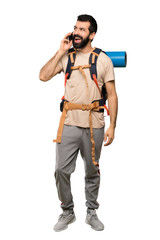 Naklejka premium Hiker man keeping a conversation with the mobile phone over isolated white background